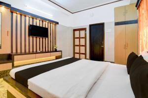 a bedroom with a large bed and a flat screen tv at Super Hotel O Howrah Railway Station in Salkhia