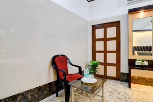 a red chair and a table in a room at Super Hotel O Howrah Railway Station in Salkhia