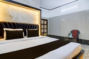 a bedroom with a large bed and a red chair at Super Hotel O Howrah Railway Station in Salkhia +21 photos