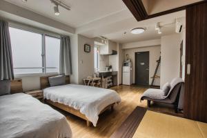 a bedroom with two beds and a living room at Gamadas BLD in Tokyo