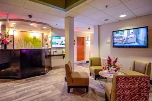 een lobby met een wachtkamer met stoelen en een tv bij Best Western Nittany Inn Milroy in Milroy