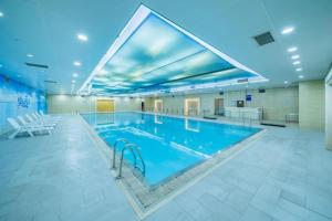 a large swimming pool in a large building at Changsha Xiaoxiang Huatian Hotel in Changsha