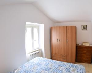 a bedroom with a bed and a wooden cabinet at La casetta dei Desideri in Poggio Bustone