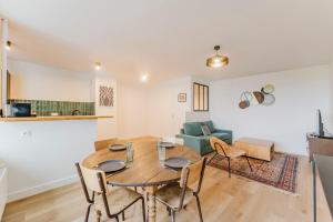 ein Wohnzimmer mit Tisch und Stühlen und einer Couch in der Unterkunft Charming apartment 2ch 4p parking and balcony in La Madeleine