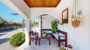 eine Terrasse mit 2 Bänken, einem Tisch und Stühlen in der Unterkunft Villa Butterfly in Kyrenia