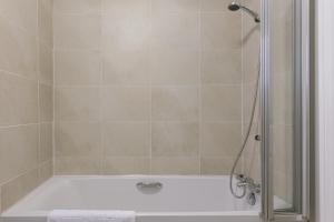 a bathroom with a shower with a bath tub at Chic 2-Bed, 2 Bath Apt in City Centre Sleeps 6, Free Secure Parking in Belfast +65 photos