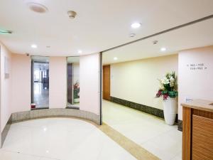 een lobby van een gebouw met een vaas met bloemen bij Nanfang Dasha Hotel in Guangzhou