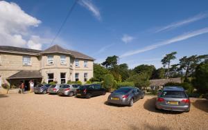 a row of cars parked in front of a house at Bourne Hall Country Hotel in Shanklin