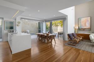 Anna Superbly Stylish Luxury Townhouse في صن شاين بيتش: مطبخ وغرفة معيشة مع طاولة وكراسي