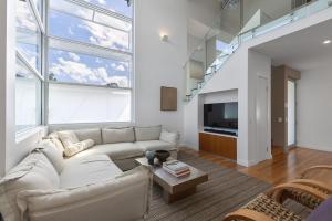 Anna Superbly Stylish Luxury Townhouse في صن شاين بيتش: غرفة معيشة مع أريكة وتلفزيون