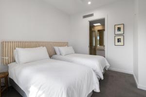 Anna Superbly Stylish Luxury Townhouse في صن شاين بيتش: سريرين في غرفة مع ملاءات بيضاء +12 صورة