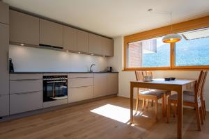 a kitchen with a table and chairs and a window at Gommer Sunna - Joderestutz in Reckingen - Gluringen