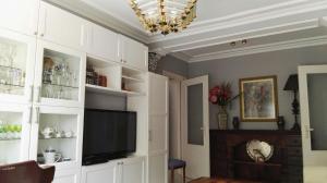 a living room with a television and white cabinets at TRIANA HOME & Free Parking in Seville