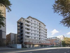 a large white building on the side of a street at Jinjiang Inn Changchun Xi An Avenue Branch in Changchun