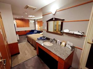 a hotel room with a sink and a bed at ホテル Ano in Kanuma