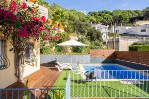 a balcony with a swimming pool and an umbrella at Lloret · Villa Gamené piscina y mar in Lloret de Mar