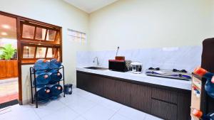 a kitchen with a sink and a counter top at Yuwono Hotel & Villa Malioboro in Sentool