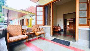 a porch with two chairs and a table and a couch at Yuwono Hotel & Villa Malioboro in Sentool