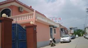 een scooter geparkeerd voor een gebouw bij Lianyungang Jianyuan Hotel in Nancheng