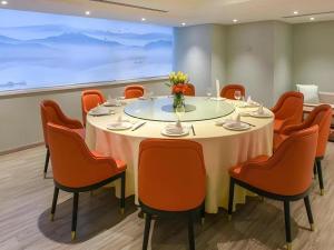 a conference room with a round table and orange chairs at Deacon House Wuxi in Wuxi