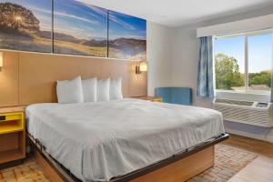 a hotel room with a bed and a window at Days Inn by Wyndham Omaha - West Dodge in Omaha +84 photos