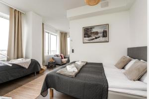 a white room with a bed and a couch at Topaasi - Nokia Arena by Come in! in Tampere