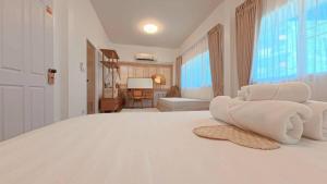 a white bedroom with a bed with towels on it at Center of old town - 3BR 3BA - Nara Lanna Villa in Chiang Mai
