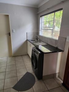 een keuken met een wasmachine en een wastafel bij Westbrook in Newcastle +2 foto's