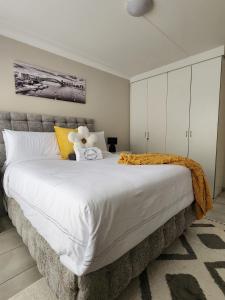 een slaapkamer met een groot bed met een teddybeer erop bij Westbrook in Newcastle