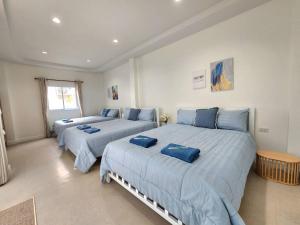 three beds in a bedroom with blue sheets at Serene Poolvilla hatyai in Hat Yai +58 photos