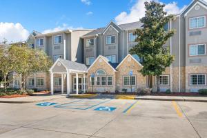 a large apartment building with a parking lot at Microtel Inn & Suites by Wyndham Pearl River/Slidell in Pearl River