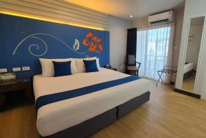 a bedroom with a large bed with a blue wall at Days Inn by Wyndham Patong Beach in Patong Beach +39 photos