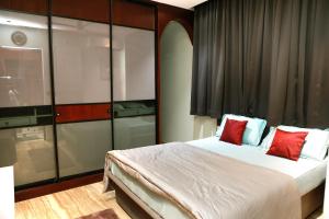 a bedroom with a large bed with red pillows at VLuv Home Stay in Chennai