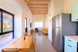 a kitchen with a wooden table and a refrigerator at צימרים למשפחות, אירוח ~כימים אחדים~ משק אביגור-מקובר in Giv'at Yo'av