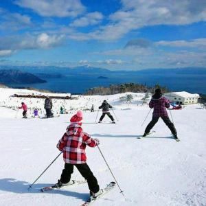 a group of people skiing down a snow covered slope at Imazu Sun Bridge Hotel in Imazu