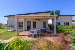 a small white house with a table and chairs at צימרים למשפחות, אירוח ~כימים אחדים~ משק אביגור-מקובר in Giv'at Yo'av +28 photos