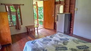 Ban Laem SaiにあるAffordable shackの冷蔵庫とベッドが備わる客室です。