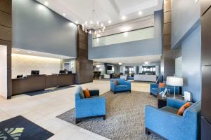 an office lobby with blue chairs and a waiting area at Wingate Slidell New Orleans in Slidell