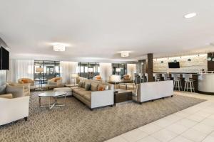 a living room with couches and a bar at Wingate Slidell New Orleans in Slidell