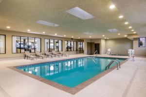a pool in a hotel with chairs and tables at Wingate Slidell New Orleans in Slidell