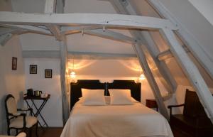 um quarto com uma cama grande e lençóis brancos em Le Clos Sainte-Marie em Mesland