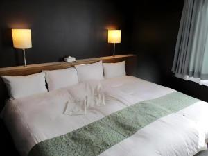 NuttariにあるNiigata Keihin Hotelの白いシーツと枕が備わった大きなベッド