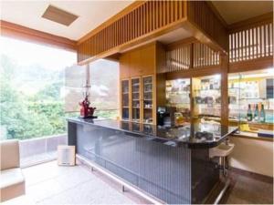 a large kitchen with a counter and a large window at Yufuin Onsen Yufuin Nanairo no Kaze in Yufuin