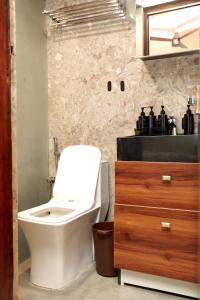 a bathroom with a white toilet and a sink at VLuv Home Stay in Chennai +50 photos
