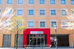a large building with a red and blue facade at AI HOTEL OYAMA in Oyama