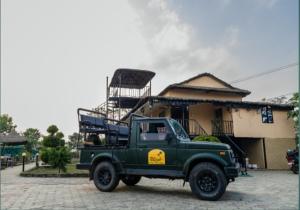 a green truck parked in front of a building at Hotel RaptiRiverview in Khargauli