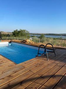 a chair sitting on a deck next to a swimming pool at Carsium View House in Hîrşova