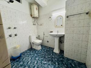 un baño con inodoro y lavabo en Hotel Inn Way #Near Beas River, en Manali