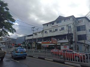 a car driving down a city street with a building at RedDoorz near Sam Ratulangi Manado in Manado