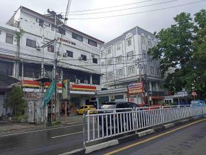 a city street with buildings and cars on the road at RedDoorz near Sam Ratulangi Manado in Manado +14 photos